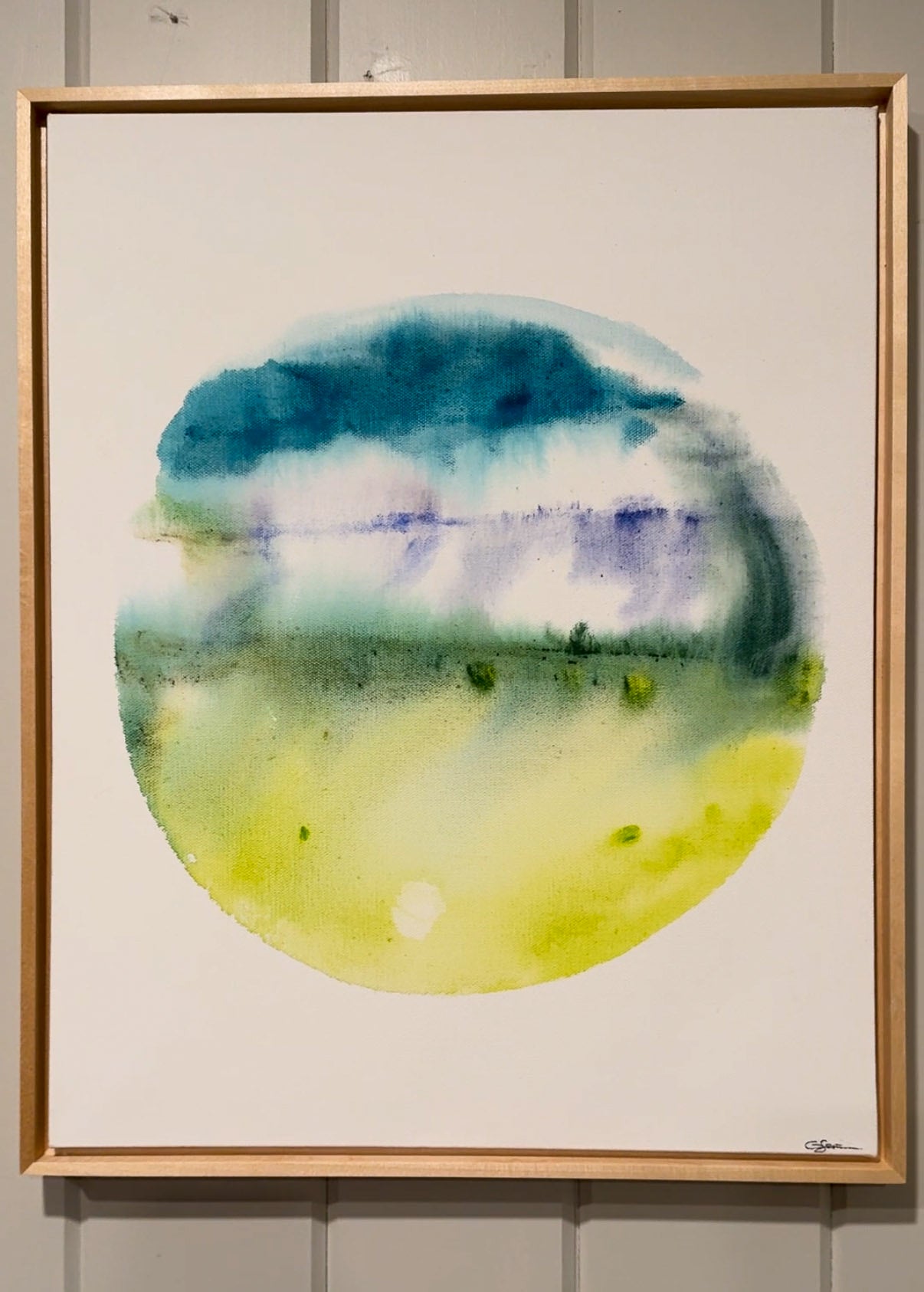 Framed watercolor painting with circular design in blue, green, and purple on a white background.