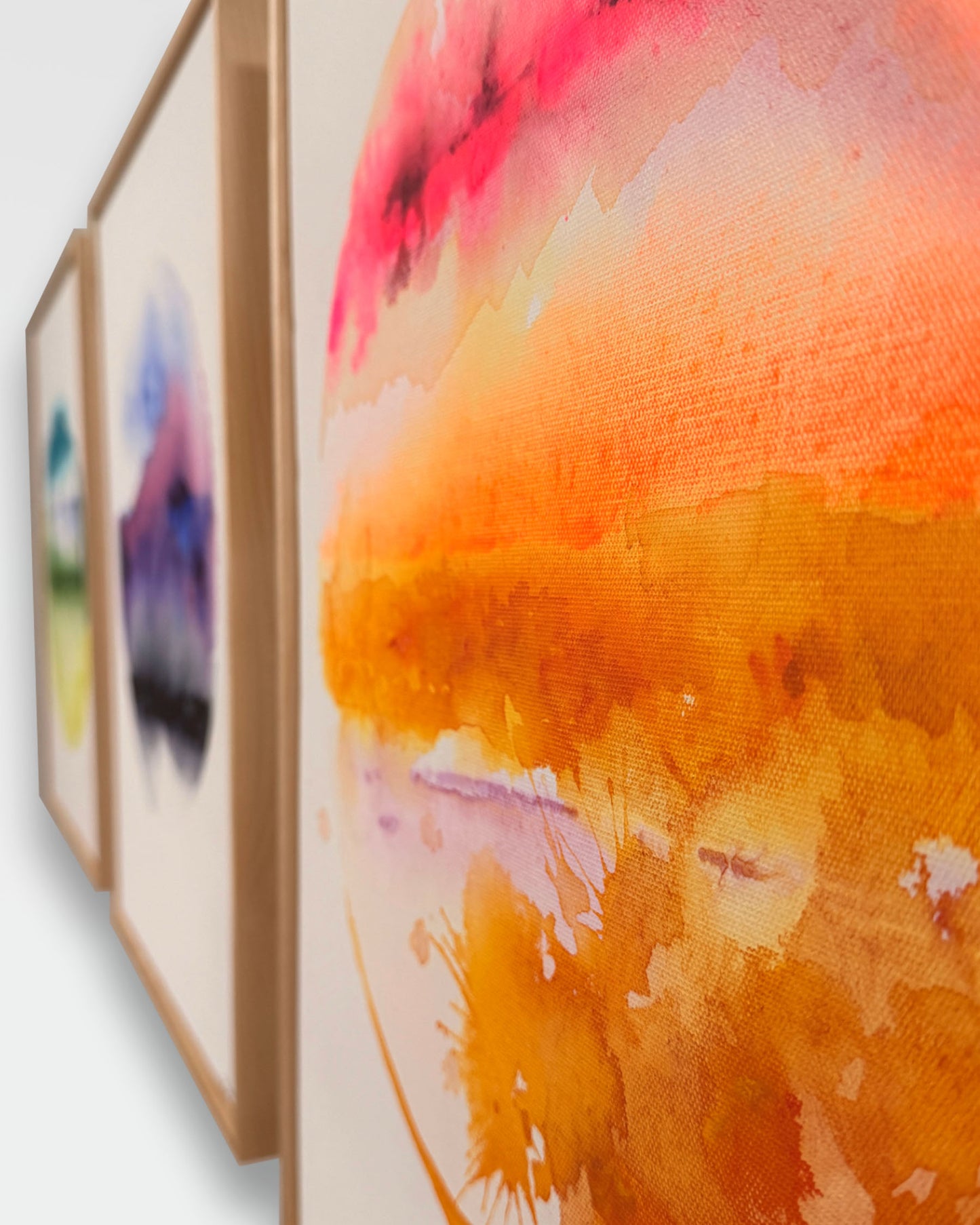 Set of three watercolor paintings with a focus on a vibrant orange and pink abstract piece.