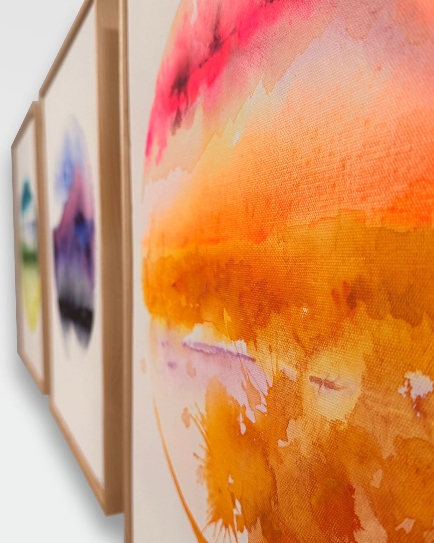 Set of three watercolor paintings with a focus on a vibrant orange and pink abstract piece.