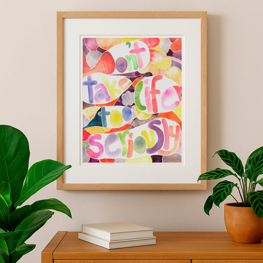 Framed colorful artwork with motivational quote on a wall with plants and books below.